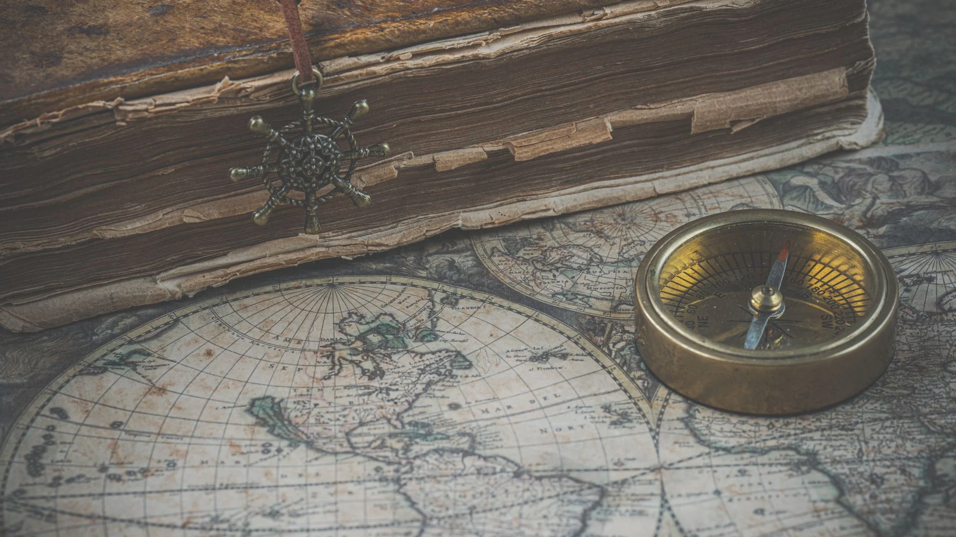 Antique map, compass and book arranged for historical research