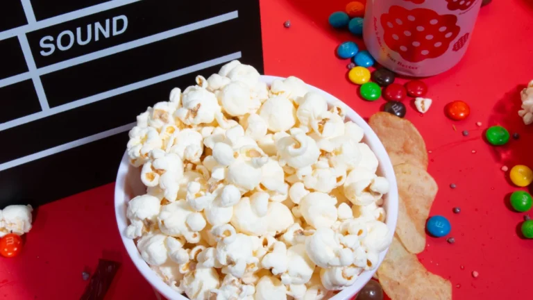 Popcorn, movie snacks and a clapperboard on a table