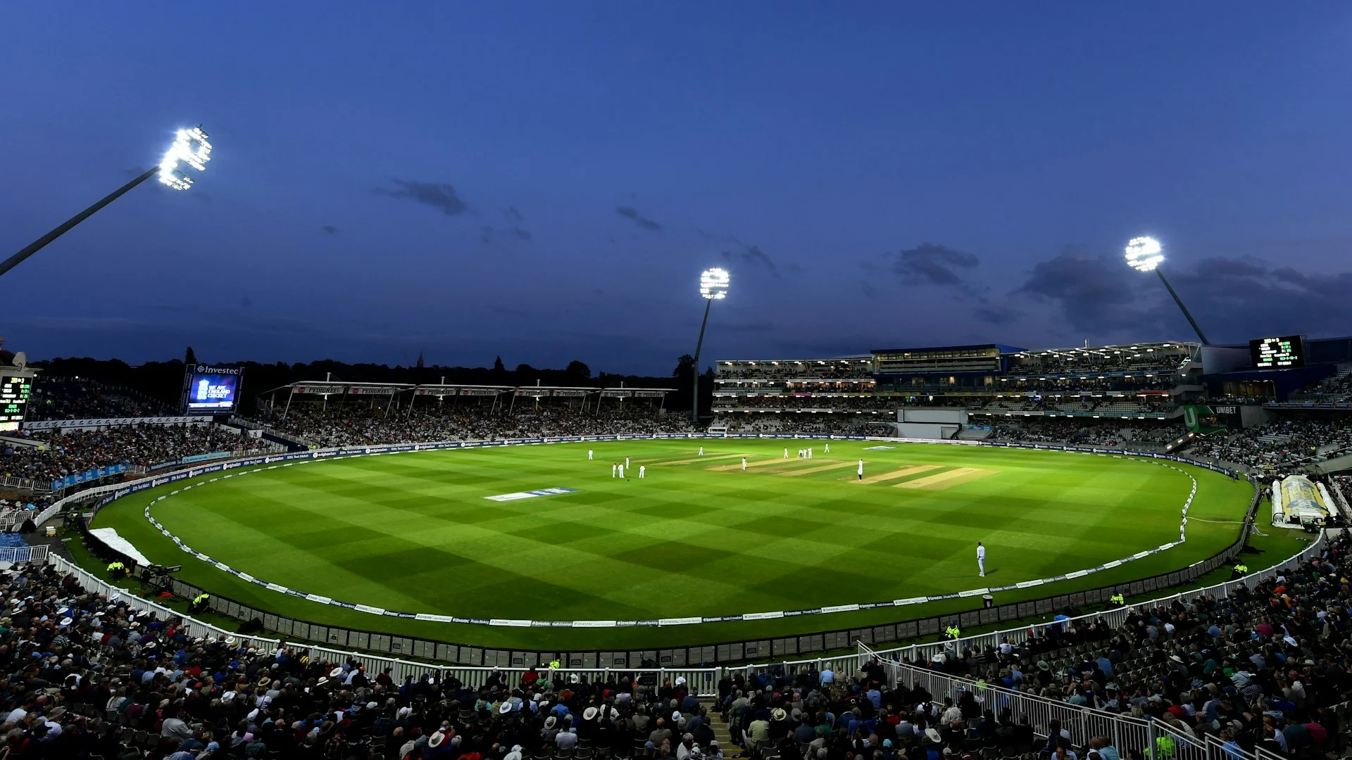 Illuminated cricket stadium viewed from the stands