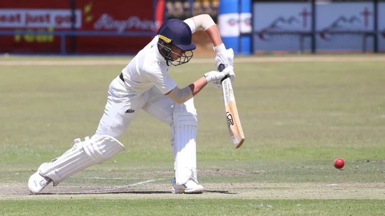 Cricket player batting on a grass field; illustrative sports photograph